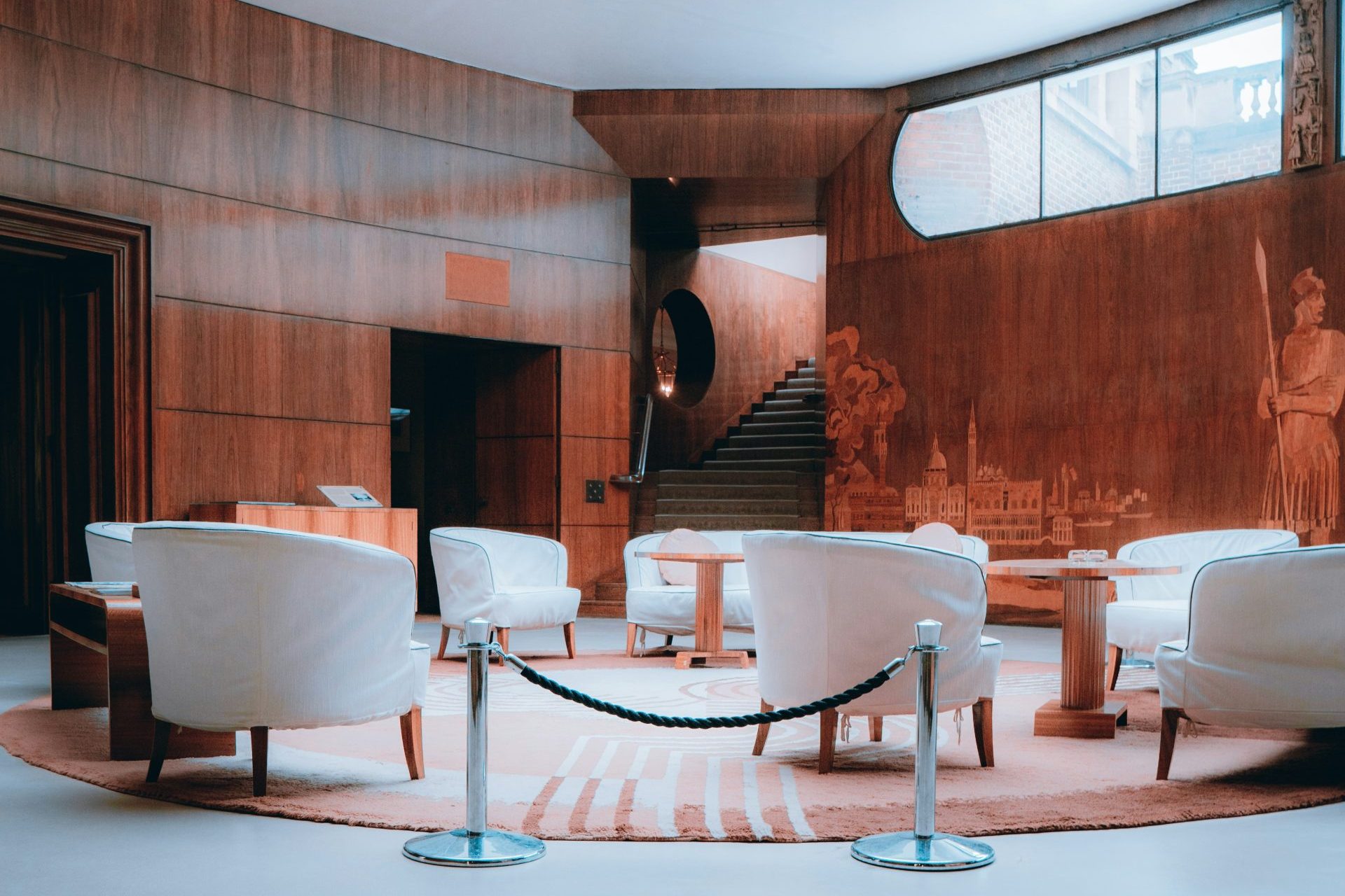 a room with a circular ceiling and white chairs